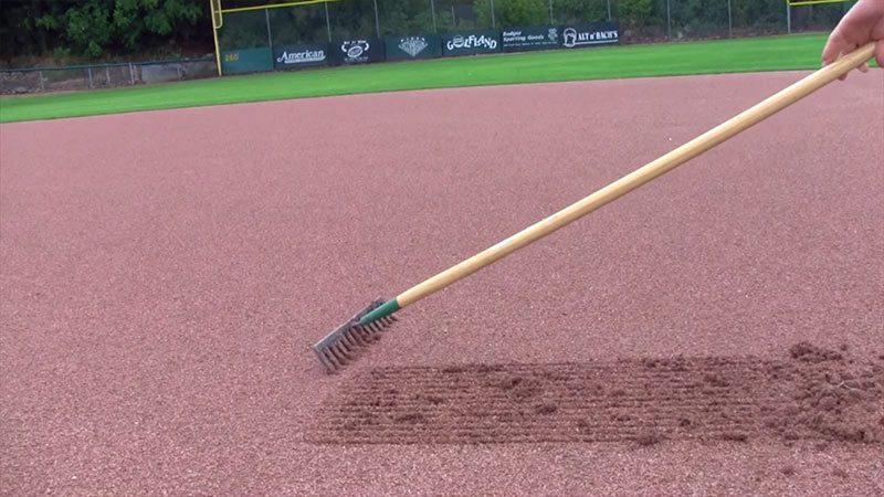 Image of Rake dragging across the ground, leaving a smooth, even surface