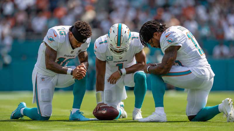 why do quarterbacks kneel in the huddle